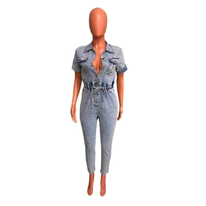 Detail view of light blue washed denim jumpsuit with elastic waist and chest pockets