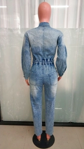 Detail view of the elastic waist and back pockets of light blue denim jumpsuit