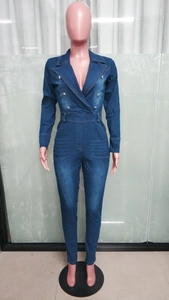Detail of slim fit dark blue denim jumpsuit with double-breasted buttons and lapel collar