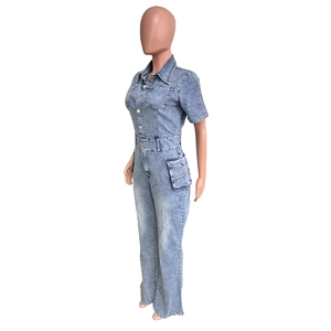 Detail view of the classic lapel, button-down closure and chest pockets on denim jumpsuit