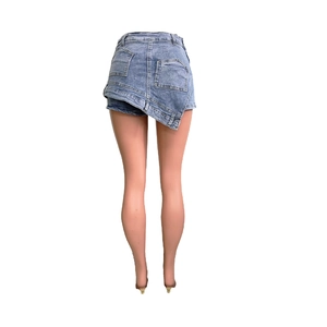 Detail view of light blue denim mini skirt with asymmetric hem and back patch pockets