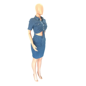 Detail of blue denim two-piece set featuring a button-up tied top and slim fit mini skirt