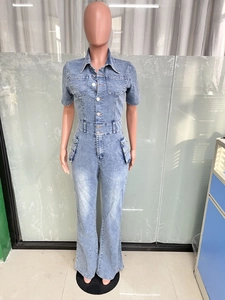 Detail of light blue washed denim jumpsuit featuring cargo pockets and button closure