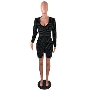 Détail d'une mini robe noire à manches longues avec décolleté en V et strass argentés brillants