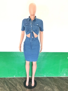 Detail of blue denim two-piece set featuring short sleeve tie-front crop top and mini skirt
