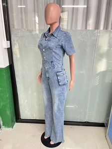 Detail of light blue wash denim jumpsuit featuring short sleeves and utility cargo pockets