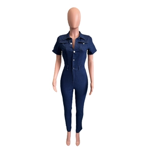 Detail of slim fit dark blue denim jumpsuit with short sleeves and front button pockets