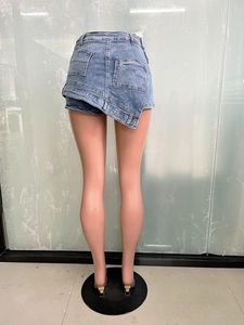 Detail of light blue denim skort with asymmetric overlap design and functional back pockets