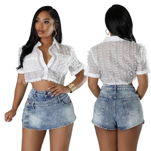 Detailed view of white textured crop shirt and multi-button light blue denim skirt combo