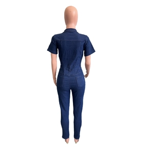 Detail view of the back of a slim fit dark blue denim jumpsuit with waist loops and pockets