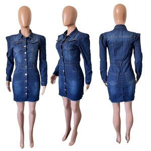 Detail view of dark blue denim mini dress with puff sleeves and frayed hem details