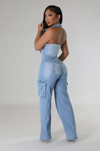 Detail view of light blue denim jumpsuit with cargo pockets and halter neck design