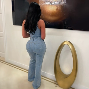 Vista posteriore della tuta in denim attillata con gamba svasata e vita alta