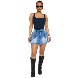 Détail d'une mini-jupe en jean bleu clair avec poches cargo et effet éclaboussures blanches