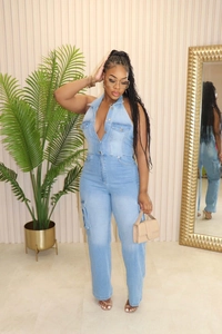 Detail of light blue washed denim jumpsuit with metal buttons and cargo pockets