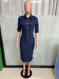Détails d'une robe en jean bleu foncé avec boutons métalliques et fente sur l'ourlet