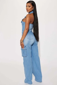 Detail of light blue denim halter neck jumpsuit featuring cargo side pockets and wide leg cut
