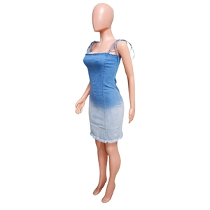Detail of ombre denim mini dress with adjustable tie straps and frayed raw hem edge