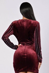 Vue détaillée du dos d'une robe courte en velours bordeaux avec strass sur les manches