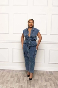 Detail of blue wash denim jumpsuit showing drawstring waist and cargo side pockets