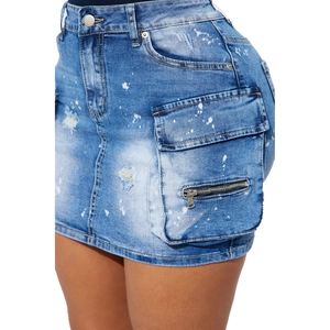 Détail macro de mini-jupe en jean bleu avec éclaboussures de peinture et zip métallique