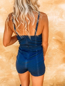 Rear view of slim fit dark blue denim romper with thin straps and back zipper closure
