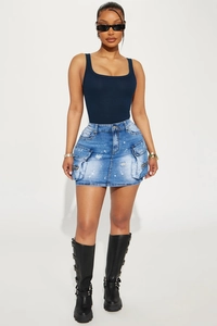 Détail d'une mini-jupe en jean bleu avec de grandes poches à rabat et des zips
