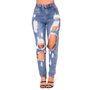 Close-up of high waist ripped jeans featuring heavy distressed details and blue denim texture