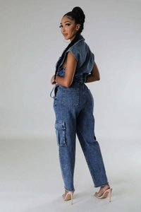 Detail of cargo pockets and frayed edges on denim jumpsuit with snow wash finish