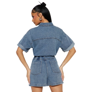 Detailed view of mid-blue washed denim playsuit with elastic waist and back pockets