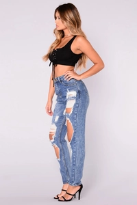 Side view of high-waist light blue ripped jeans with distressed details and cat whiskers