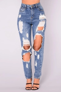 Detailed close-up of light blue high-waisted skinny jeans with ripped knees and raw hems