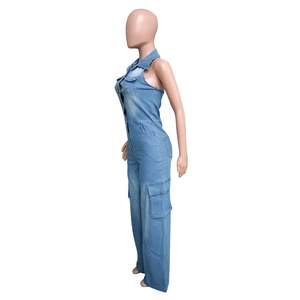 Detail view of denim jumpsuit showing side cargo pockets and washed blue fabric texture