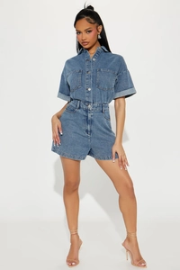 Detail of light blue denim romper featuring lapel collar, metal buttons and chest pockets
