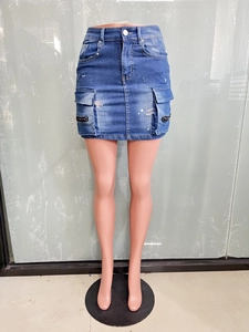 Détail d'une mini-jupe en jean avec poches cargo, trous usés et touches de peinture blanche
