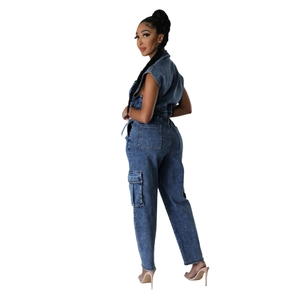 Detail view of a slim-fit navy denim jumpsuit with utility pockets and a cinched waist