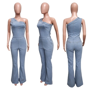 Dettaglio tuta in denim celeste monospalla con fondo a campana e cerniera laterale invisibile
