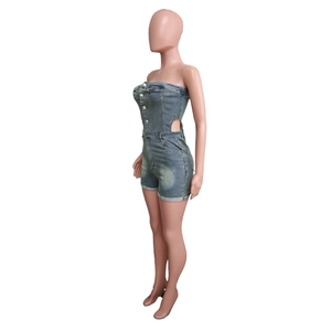 Detail of blue washed denim tube romper with side cut-out and metal buttons