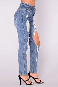 Close-up of high-waist ripped denim jeans in vintage blue with distressed details