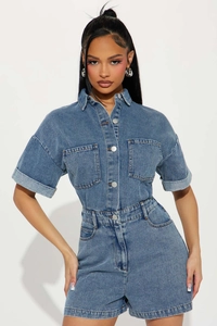 Detail shot of blue denim jumpsuit showing metal buttons and front chest pockets