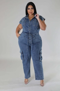 Detail of blue denim jumpsuit showing waist drawstring and cargo pockets with raw hem