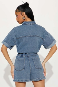 Back view of washed denim romper featuring elastic waist and large rear pockets