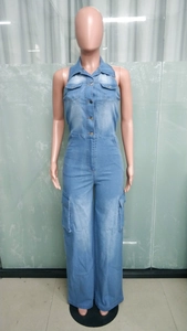 Detail view of light blue denim jumpsuit with chest pockets and cargo style leg pockets