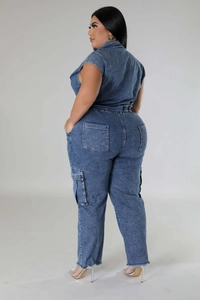 Detail view of denim jumpsuit with cargo pockets and raw hem finish on a model