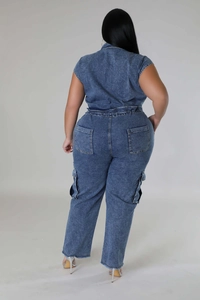 Detail of blue denim jumpsuit back view with utility pockets and frayed hemline