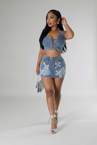 Detailed view of denim two-piece set featuring cross embroidery and halter top design
