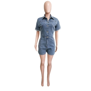 Detailed close-up of dark blue denim short jumpsuit with turn-down collar and utility pockets