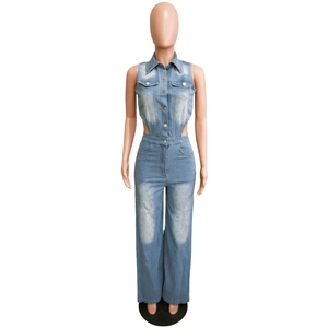 Détail d'une combinaison en jean bleu clair avec découpes à la taille et boutons
