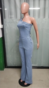 Dettaglio di tuta in denim lavato azzurro con monospalla e gambe a campana