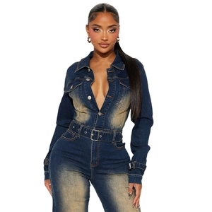 Detail of washed denim jumpsuit featuring metallic buttons and matching pin buckle belt